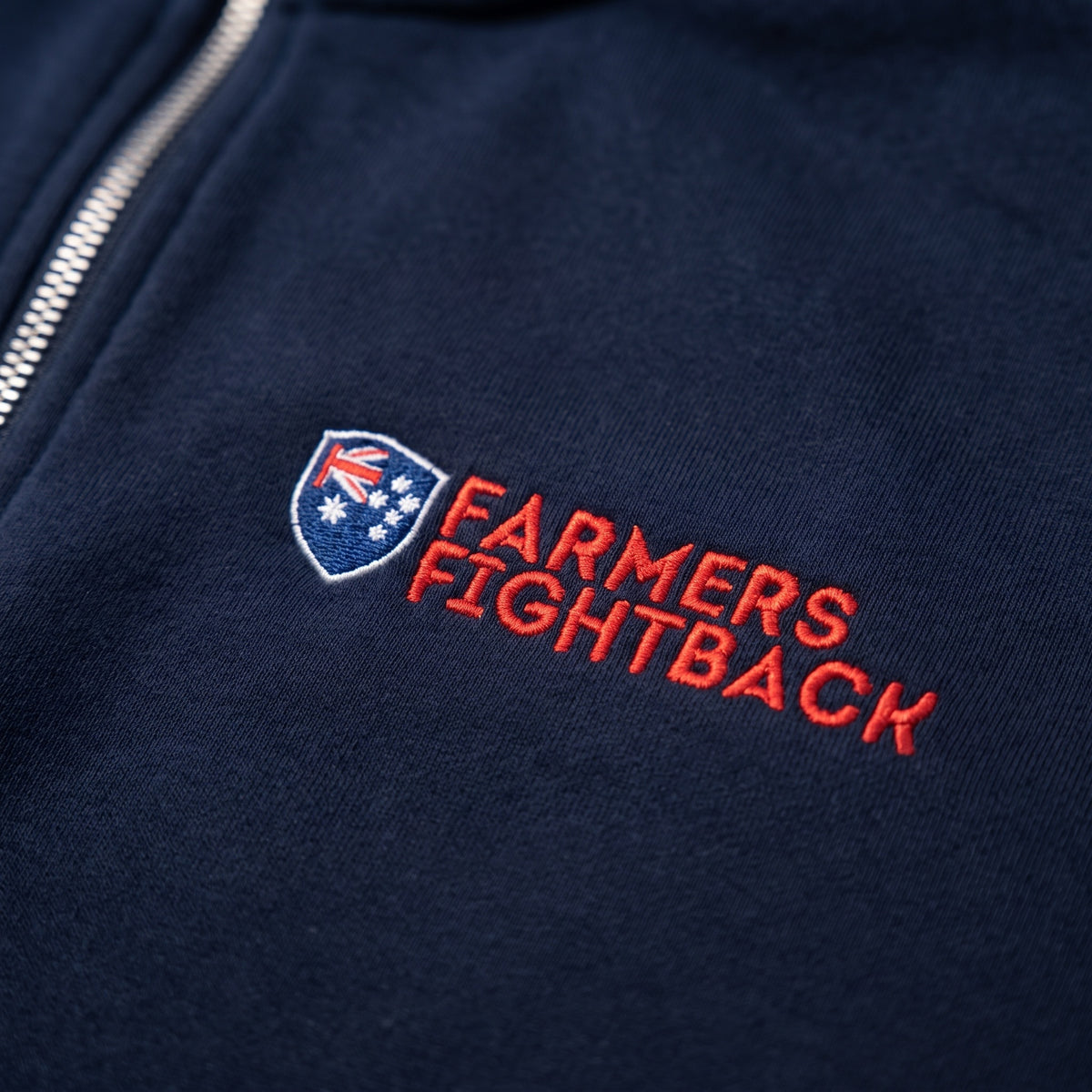 Close up of the embroidered Farmers Fightback badge on navy fleece