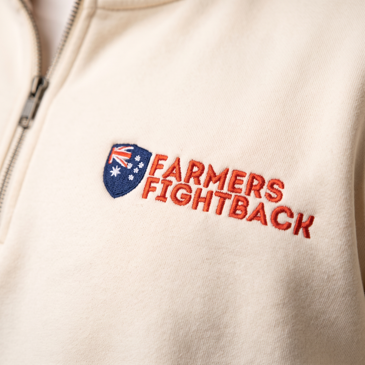 Close up of the embroidered Farmers Fightback badge on cream fleece